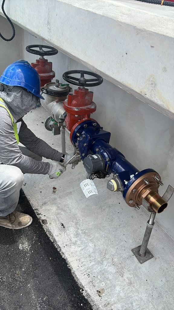 A PEC crew member installing a backflow preventer assembly on a South Florida jobsite